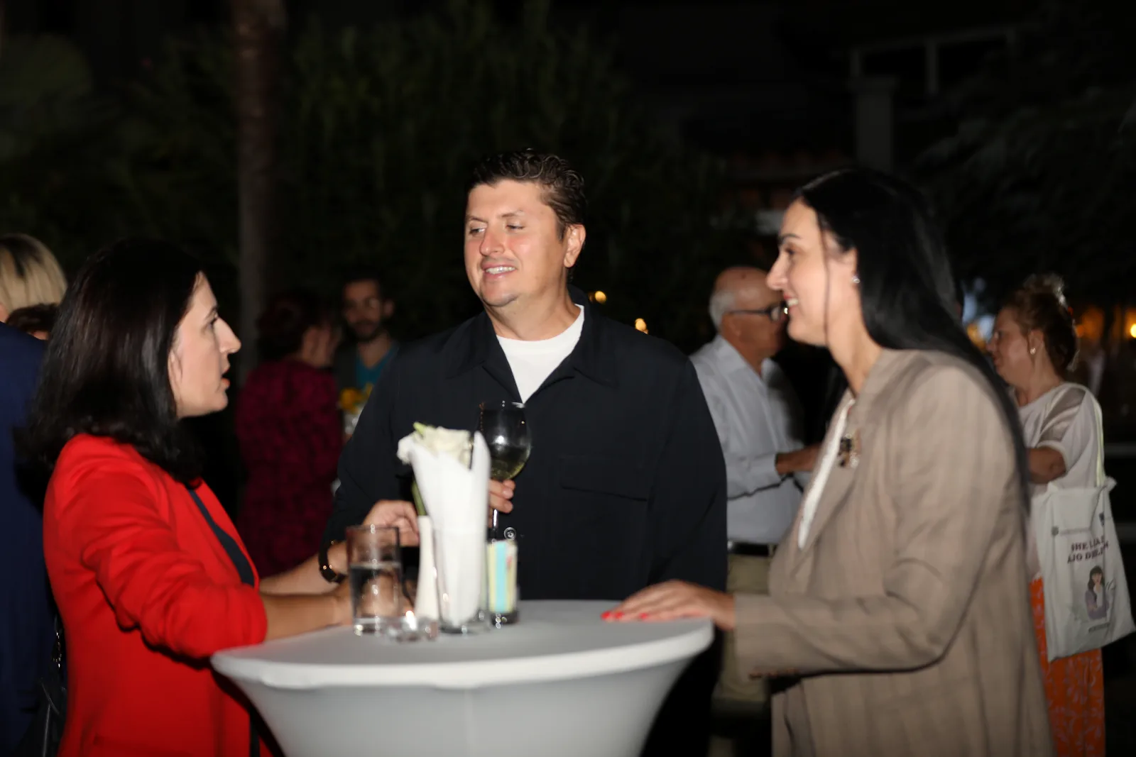 Guests talking at a standing table during the evening