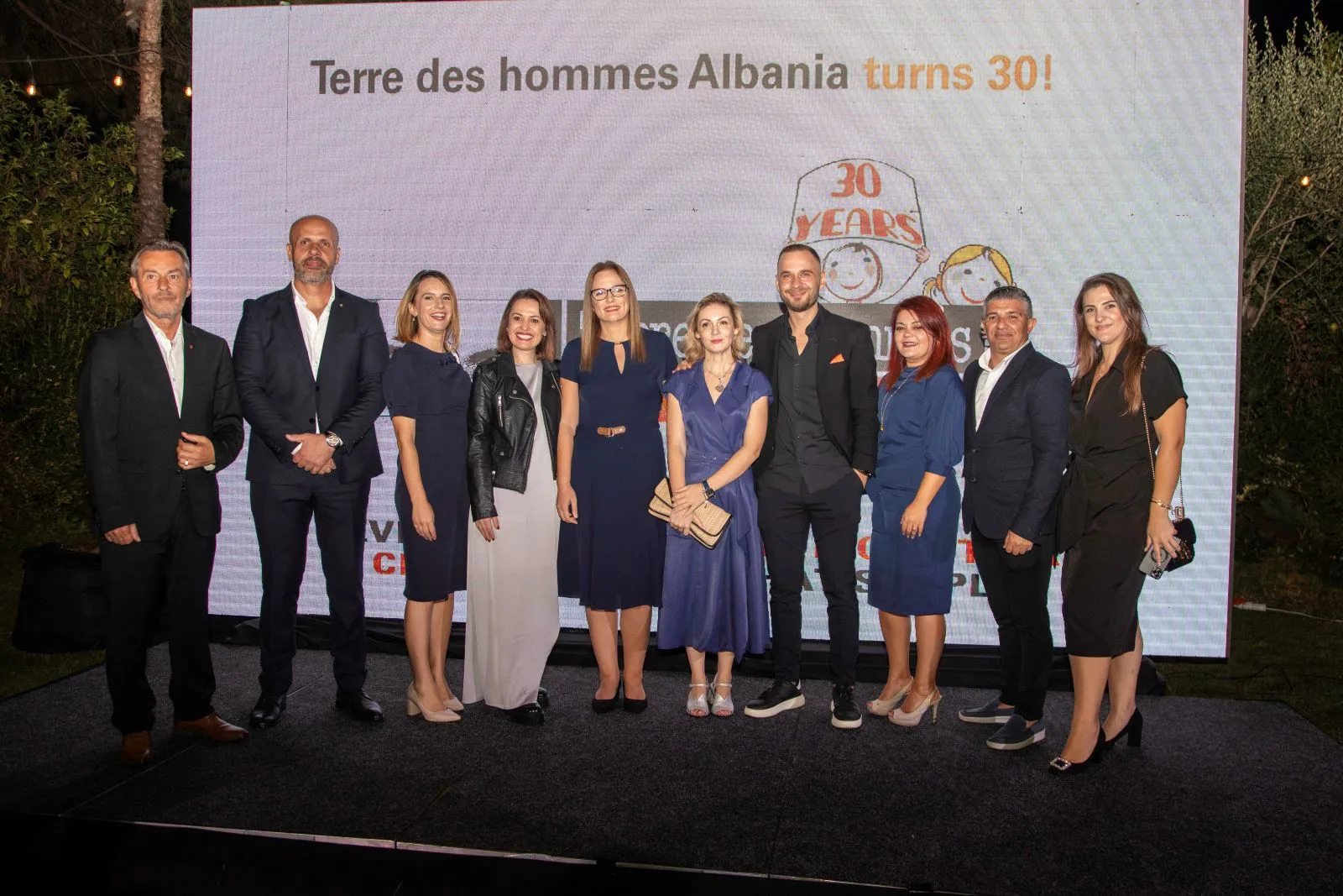 The Tdh Albania team on stage in front of the “turns 30!” screen